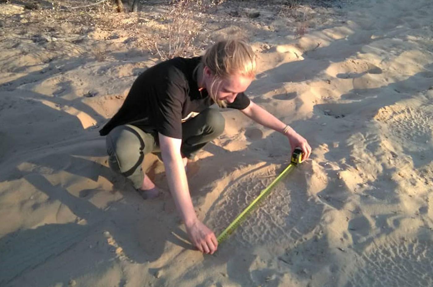 Emma measuring elephant prints.